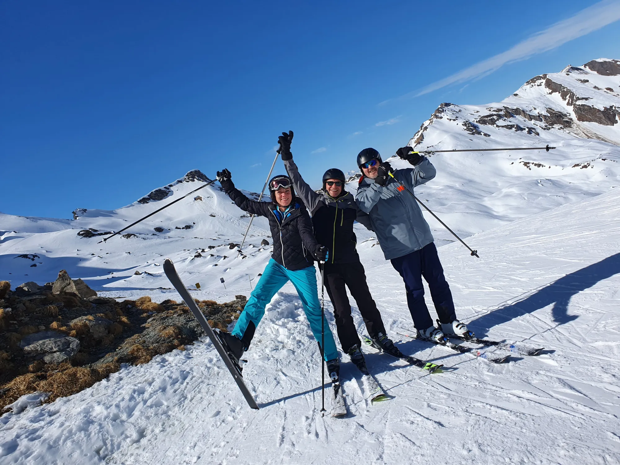 Drei ASKÖ-bfi Mitglieder jubeln auf Skiern am Gipfel