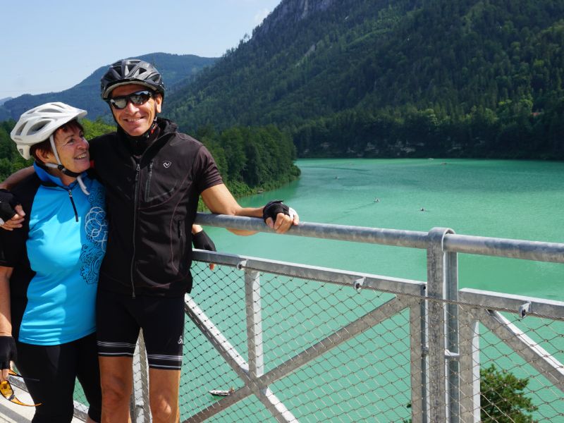 Zwei Radfahrer am Geländer eines türkisen Sees