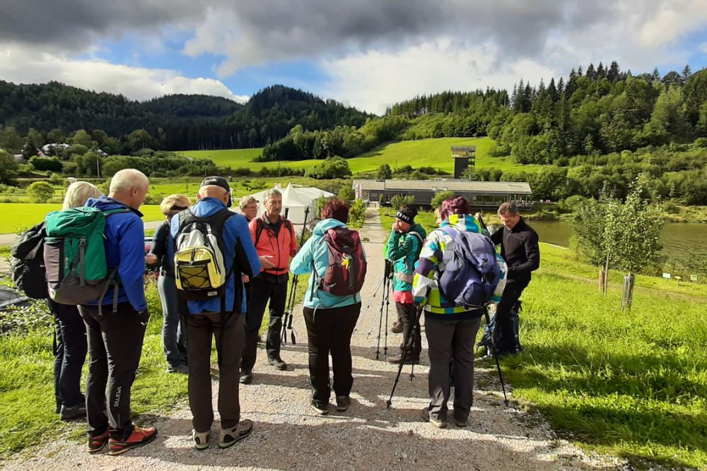 Wandergruppe auf einem Weg neben einem See